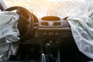 Damaged car dashboard with airbags that has been inflated for Takata airbag deaths blog post