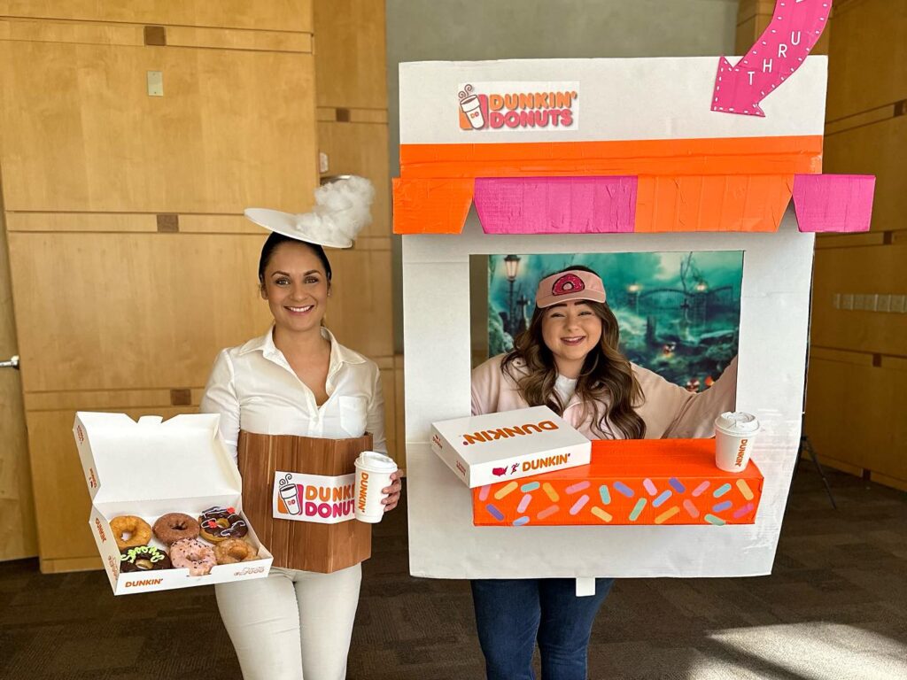 two people dressed up as dunkin donuts window for halloween