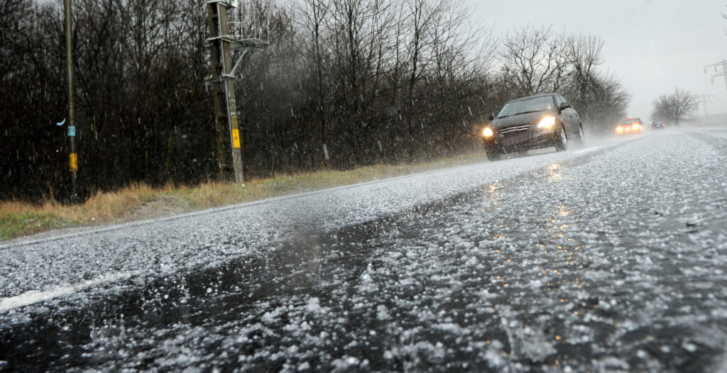 image of car driving on icy road for winter driving tips blog post