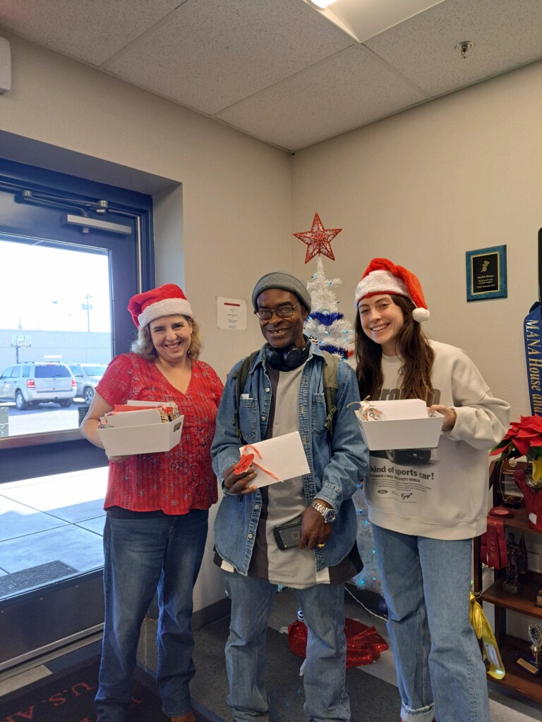 two volunteers with mana house resident and christmas cards