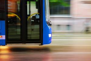 city bus moving fast down street