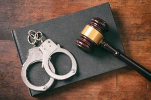 handcuffs on book next to gavel