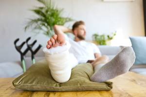 injury victim with broken leg relaxing at home