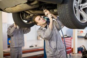 mechanic under vehicle checking things