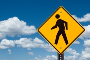 pedestrian walking sign photographed against the sky