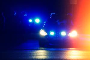 blue police lights on car heading down road