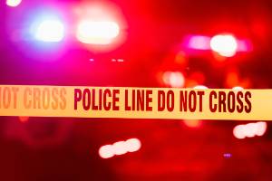 red and blue police lights behind police line