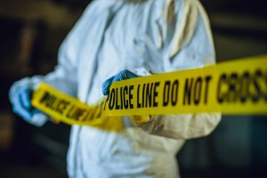 crime scene officer putting up police tape