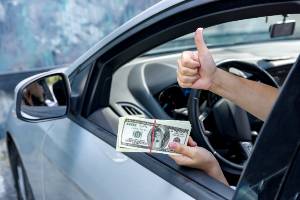 thumbs up sign with hand holding cash