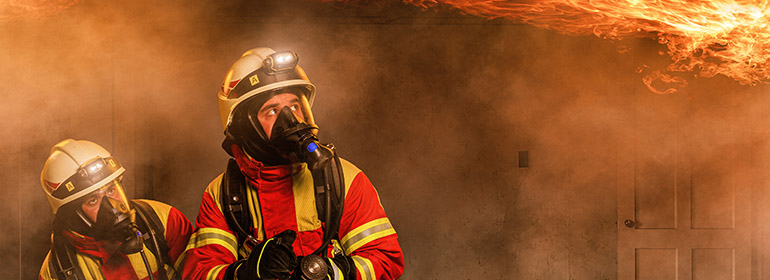 firefighters outside burning building