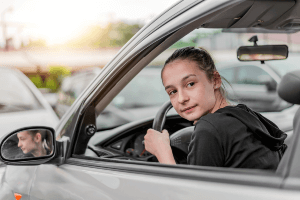 young driver looking behind car