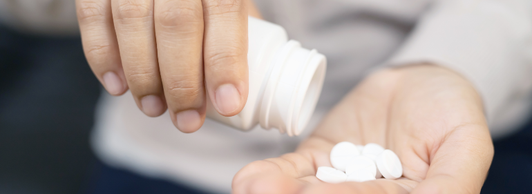 woman dumping pills into hand